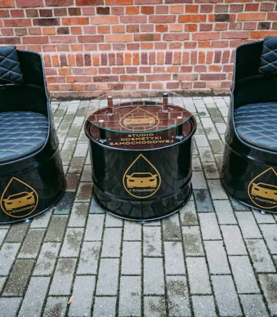 Salon en tonneaux métal upcyclés avec deux fauteuils et table basse industrielle